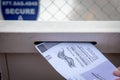Putting a mail in ballot into the drop off ballot box