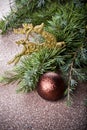 Evergreen fir tree branch, golden deer, brown ball.