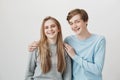 Everoyone think we siblings, but we date. Positive best friends with fair hair and braces, hugging and smiling broadly Royalty Free Stock Photo