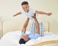 Every child wishes they could fly. a young father lying down and bonding with his son while playing with him at home. Royalty Free Stock Photo