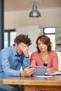 Every couple goes through tough times. a husband and wife doing their budgeting at home.