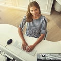 Every keystroke is a step closer to success. High angle portrait of a young woman working on a computer in her home Royalty Free Stock Photo