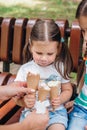 Close up of little cute girl looking at three icecream in her hands