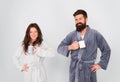 Every morning begins with coffee. Couple in bathrobes with mugs. Man with beard and sleepy woman enjoy morning coffee or