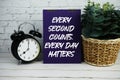 Every Second Counts, Every Day Matters text with alarm clock on wooden background Royalty Free Stock Photo