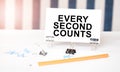 EVERY SECOND COUNTS sign on paper on white desk with office tools. Blue and white background Royalty Free Stock Photo