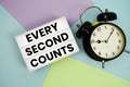 Every Second Counts text in lightbox with alarm clock flat lay on multicolor pastel background Royalty Free Stock Photo