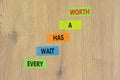 Every wait has a worth symbol. Concept words Every wait has a worth on colored paper. Beautiful wooden table wooden background.