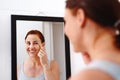 Every woman deserves flawless and moisturized skin. an at attractive young woman applying moisturizer on her face in her