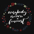 Everybody should be feminist. Feminism quote, brush calligraphy on black background with floral wreath