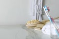 Everyday body care routine. Shower brushes, towel,soap,toothbrushes on the bathroom shelf, bathrobe hanging on the wall.Empty spac Royalty Free Stock Photo