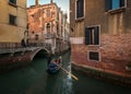 Everyday life of a gondolier. Walking on the bridges of the old city of Venice. Bright sun. The beauty of the ancient city. Italy