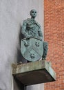 Everyman Bronze statue of a young man in medieval dress supporting the shield of the former Stratford Borough