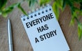 Everyone Has A Story text in notepad, wooden background. Royalty Free Stock Photo