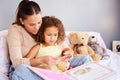 and everyone lived happily ever after. a mother reading her daughter her favourite story book.