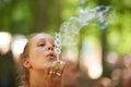 Everyone loves bubbles. a young woman blowing bubbles outside. Royalty Free Stock Photo