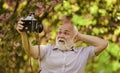 Everyone photogenic. Senior man taking selfie photo vintage camera. Self portrait. Memories in snap. Retro equipment for Royalty Free Stock Photo