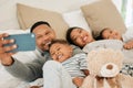 Everyone, say cheese. a beautiful young family talking and bonding in bed together. Royalty Free Stock Photo