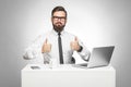 Everything alright! Portrait of handsome satisfied bearded young businessman in white shirt and black tie are sitting in office Royalty Free Stock Photo