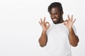 Everything is better than okay. Portrait of happy emotive african-american guy with stylish haircut, showing ok or like