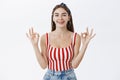 Everything fine, rely on me. Confident attractive young woman in striped top and headband showing okay gesture with both