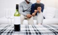 Everything goes well with a bottle of wine. an unrecognizable senior couple relaxing on a sofa with their bottle of wine Royalty Free Stock Photo