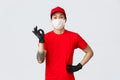 Everything good. Charismatic asian delivery guy in red t-shirt and cap assure client package is safe, employee wear