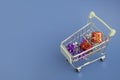 Everything for the holiday and gift wrapping, boxes and bows in a basket cart on a purple background with copy space Royalty Free Stock Photo