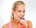 Everything in moderation. fit young woman in exercise clothes eating a chocolate bar.