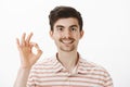 Everything is okay. Studio shot of cheerful friendly-looking caucasian guy with moustache and beard, raising hand with