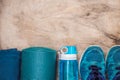 Everything for sports turquoise, blue shades on a wooden background. Yoga mat, sport shoes sportswear and bottle of Royalty Free Stock Photo