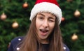 Everything will be fine for christmas. Close up Portrait of woman wearing a santa claus hat with emotion. Against the background Royalty Free Stock Photo