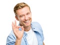 Everythings a-okay. a handsome young man standing alone in the studio and making an okay hand sign.