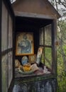 Evia Island, Greece. April 2021: Candelakia - traditional miniature Church by the road in the forest with a burning candle and ic