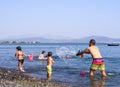 Evia Island, Greece. August 2019: Family: father, daughter and son play and pour water on the beach on a Greek island on a summer