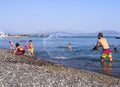 Evia Island, Greece. August 2019: Family: father, daughter and son play and pour water on the beach on a Greek island on a summer