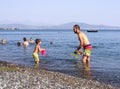 Evia Island, Greece. August 2019: Family: father, daughter and son play and pour water on the beach on a Greek island on a summer