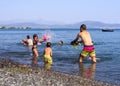 Evia Island, Greece. August 2019: Family: father, daughter and son play and pour water on the beach on a Greek island on a summer