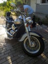 Evia island, Greece. October 2020: a Man washes a Kawasaki Vulcan motorcycle with a jet of water from a car wash in the courtyard Royalty Free Stock Photo