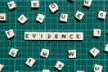 Evidence word made of square letter word on green square mat background.