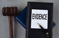 EVIDENCE - word on a white sheet with leather notebooks, a judge\'s hammer and a pen