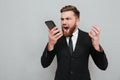 Evil bearded man in suit screaming in his smartphone Royalty Free Stock Photo