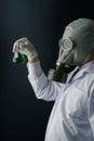 A scary scientist in gas mask holding a green toxic chemical substance flask Royalty Free Stock Photo