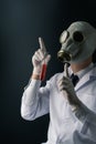 A scary scientist in gas mask holding a red chemical substance test tube Royalty Free Stock Photo