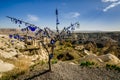 Evil eye talismans hang on a tree over volcanic rock landscape. Royalty Free Stock Photo