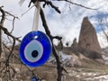 Evil eye - traditional Turkish souvenir tied up on a tree branch in Cappadocia.