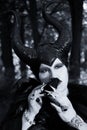 Evil fairy tale, maleficent, malevolent queen with horns and crow feather gown