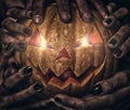 Evil pumpkin with glowing eyes that are holding