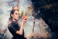 Evil Queen with Poisoned Apple in Misty Forest Royalty Free Stock Photo