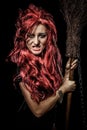 Evil red-haired witch and her broomstick Royalty Free Stock Photo